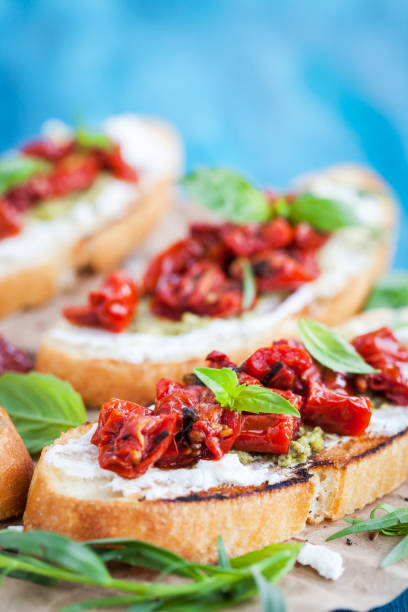 istock Bruschetta with cream cheese, pesto, fresh basil and sun dried tomatoes 692964112
