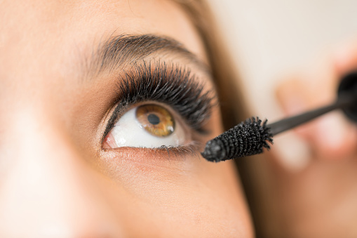 Closeup of a woman putting mascara on