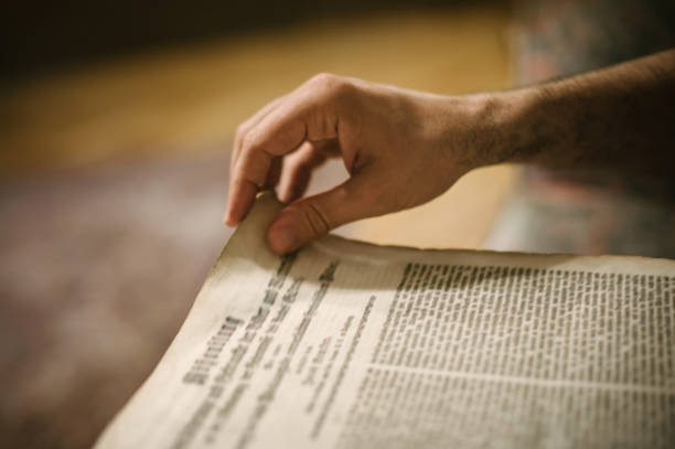 istock Curious man reading old book in his library at home 692971626