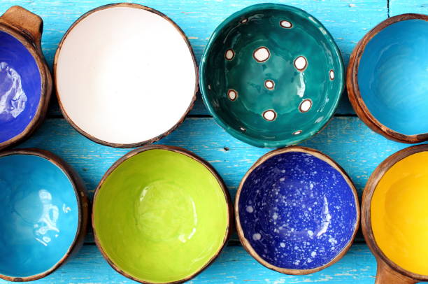 Many different bright multicolored ceramic bowls and cups handcrafted. Background texture