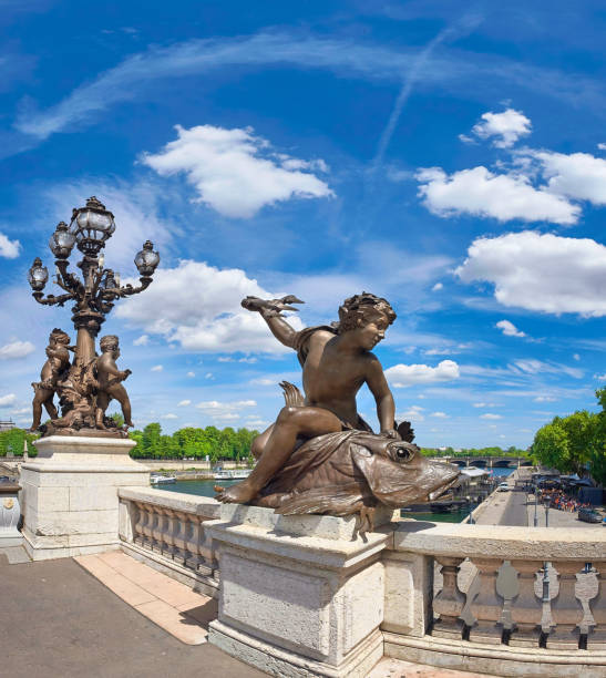 Panoramic image of bridge Pont Alexandre III in Paris with a sculpture of a boy riding a fish on the foreground