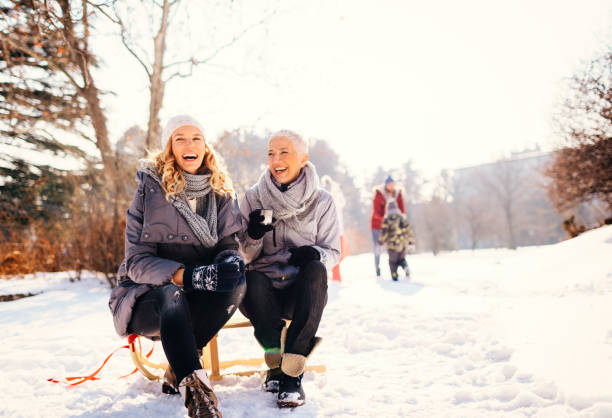 Two Generation Family Having Fun Outdoors At Winter