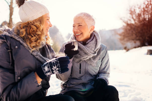 женщины пьют чай на открытом воздухе зимой - outdoors adult child sport стоковые фото и изображения