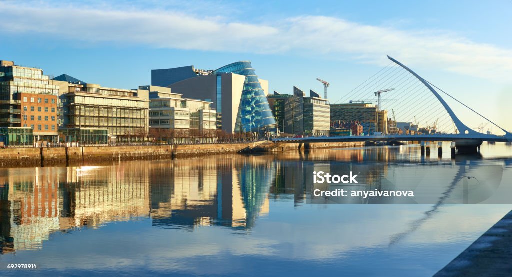 Modern buildings on Liffey river in Dublin and Harp bridge Modern buildings and offices on Liffey river in Dublin on a bright sunny day. Bridge on the right is a famous Harp bridge. Dublin - Ireland Stock Photo