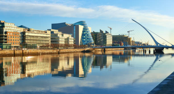 Modern buildings on Liffey river in Dublin and Harp bridge stock photo