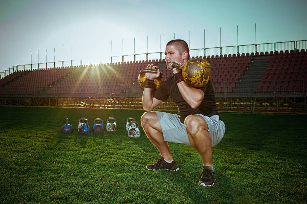 Man exercising with kettlebells outside stock photo