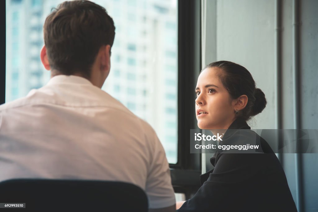 Young businesswoman discussing with businessman at office. Young businesswoman discussing with businessman at office. Teamwork, brainstorming concept. Serious Stock Photo