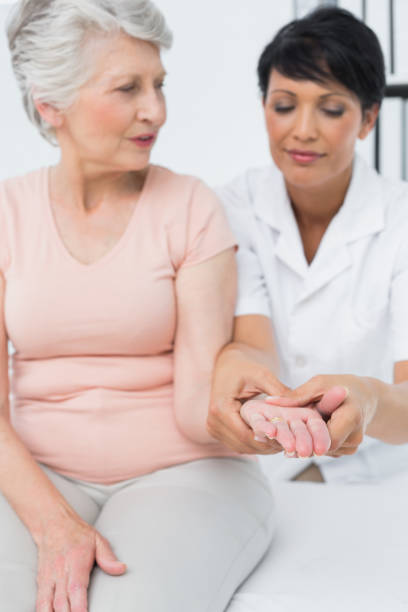 istock Female physiotherapist examining a senior patients hand 692995536