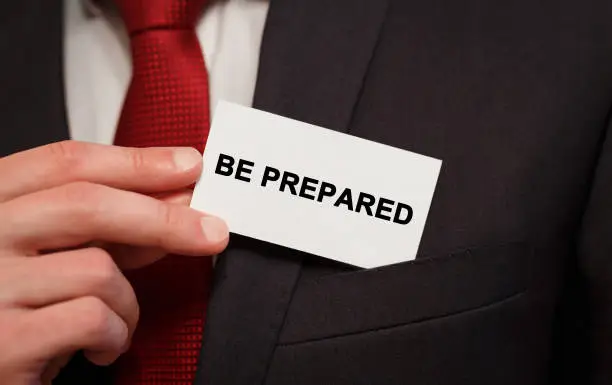 Photo of Businessman putting a card with text Be Prepared in the pocket