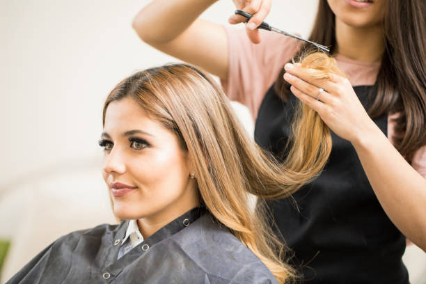 Pretty woman getting a haircut Portrait of a gorgeous young blonde getting her hair cut by a hairstylist at a beauty salon cutting hair stock pictures, royalty-free photos & images