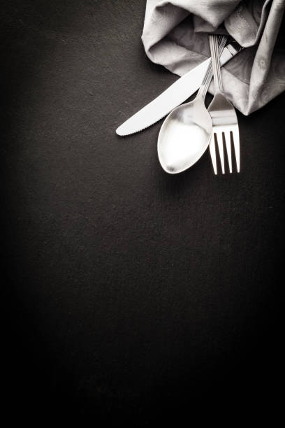 cubiertos y servilleta dispararon directamente sobre el fondo oscuro - silverware place setting napkin fork fotografías e imágenes de stock