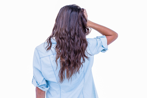 Rear view of pretty brunette with hand on head on white background