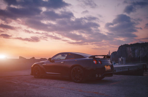 photo of a nissan gt-r black edition at the sunset. the nissan gt-r is a 2-door 2+2 sports car produced by nissan and unveiled in 2007. - edition imagens e fotografias de stock