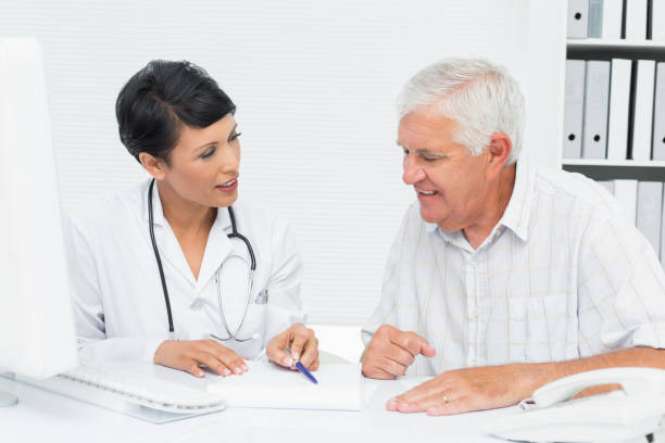 istock Female doctor with male patient reading reports 693017134