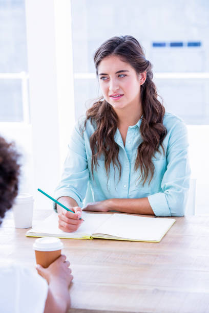 istock Concentrated woman taking notes during a meeting 693017826