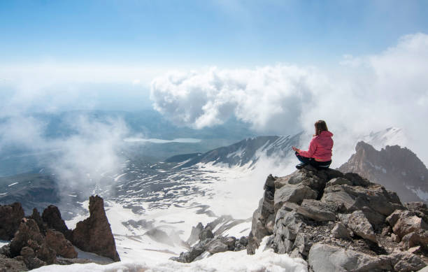 alpinista medita mentre guarda il bellissimo paesaggio in cima alla montagna in inverno - turkey extreme terrain snow nature foto e immagini stock