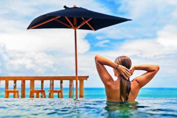 istock Woman swim in beach infinity pool with sea view 693027952