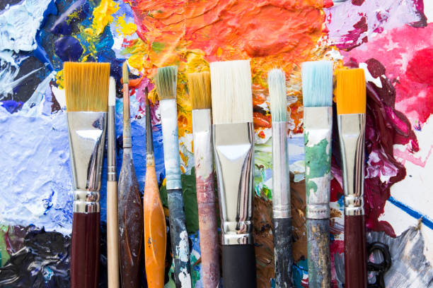 istock Concept of Individuality, Various Paintbrushes on a Palette 693028060