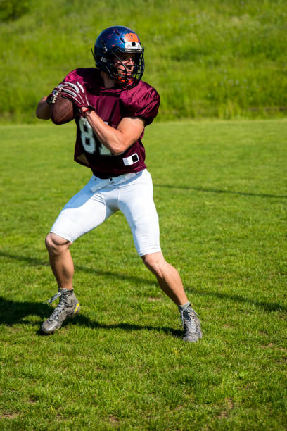 jugador de fútbol americano con una pelota en sus manos - youth league american football childhood helmet fotografías e imágenes de stock