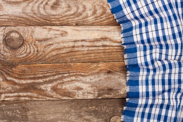 istock blue checkered tablecloth on the old wooden table with copy space for your text. Top view 693037752