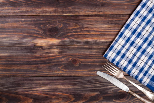 istock blue checkered tablecloth on the black wooden table with copy space for your text. Top view 693040682