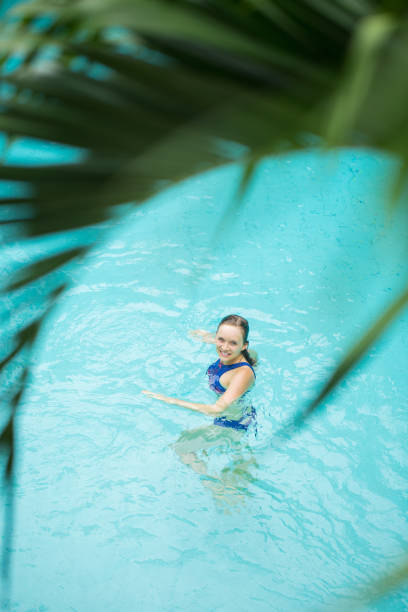 istock Cheerful woman spending time in swimming pool 693041234
