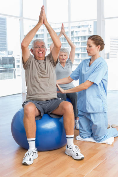 istock Female therapist assisting senior couple with exercises 693041620