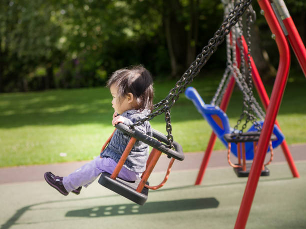 istock baby girl playing swing 693041758