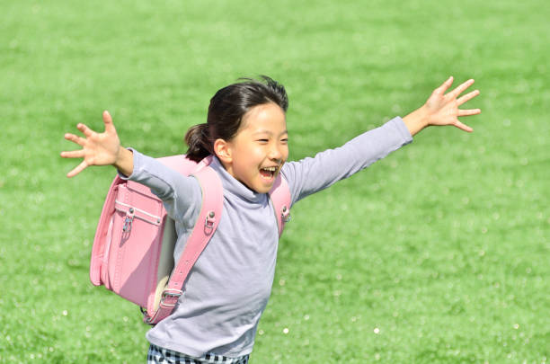 istock Girl running in lawn square (school bag) 693044798