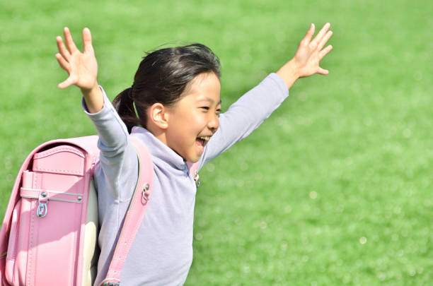 istock Girl running in lawn square (school bag) 693047042
