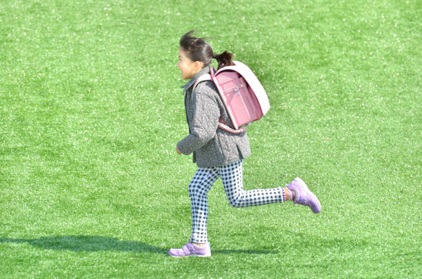 ragazza che corre in piazza prato (borsa da scuola, inverno) - randoseru foto e immagini stock