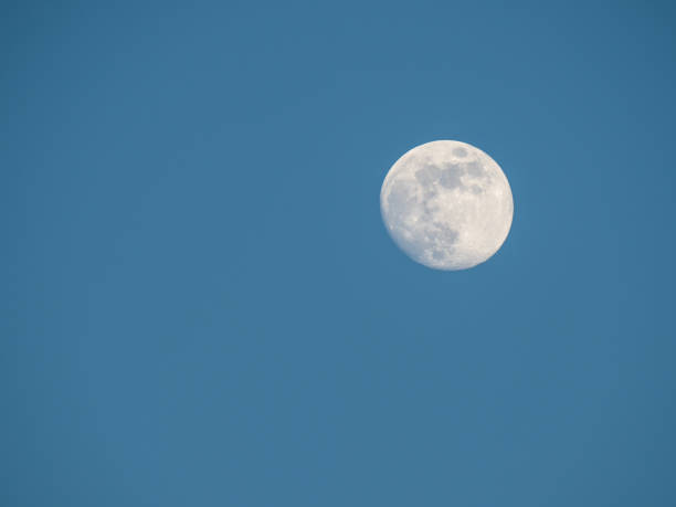 istock near full moon and cloudless blue sky 693055102