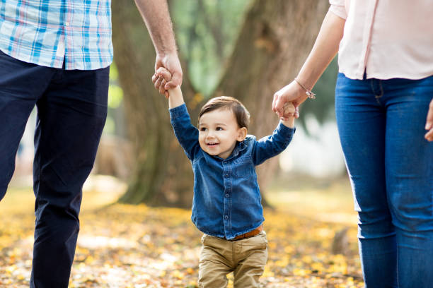 istock Happy latin boy holding parents' hands 693060938