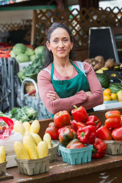 istock Hispanic woman working at fruit and vegetable stand 693063898