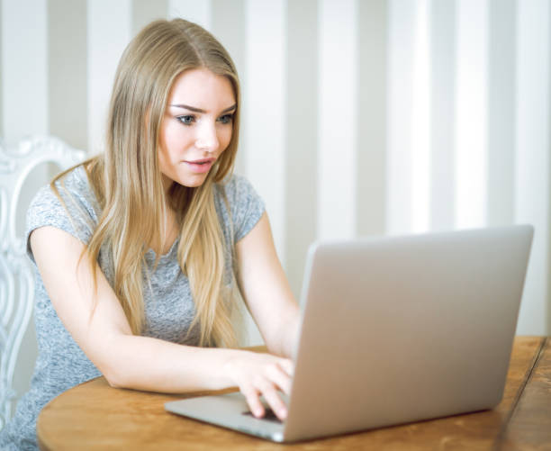 istock Beautiful young woman working with laptop 693064036