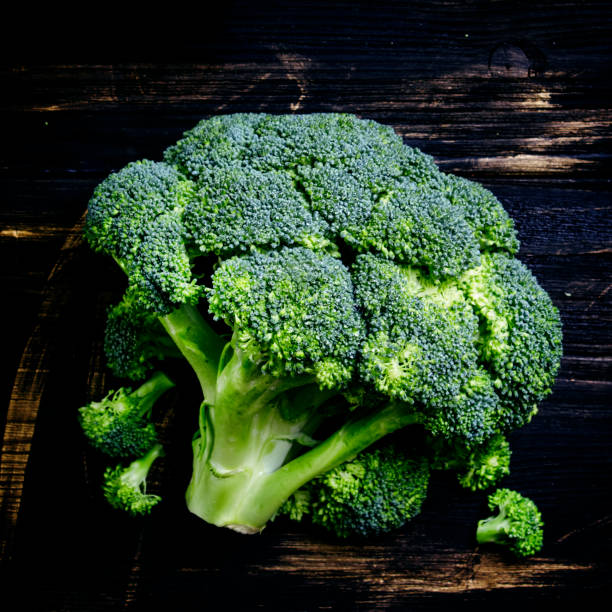 istock Fresh broccoli on a dark wooden background 693064278