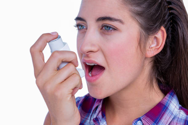 istock Pretty brunette woman using asthma inhaler 693066962