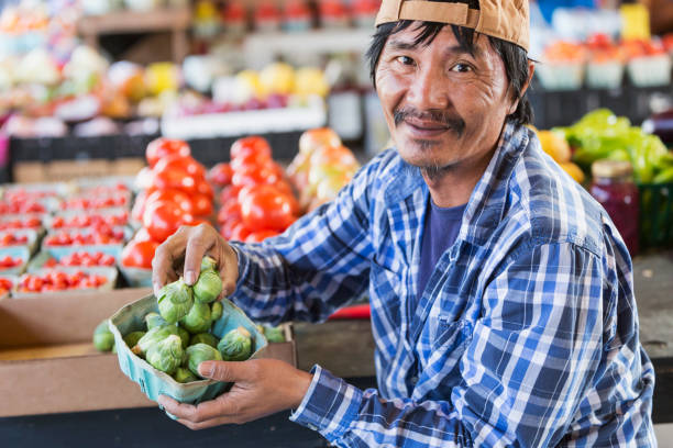 istock Mature Asian man working in produce market 693070078