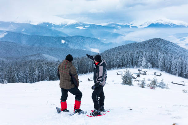 istock Two man on Snowshoeing look at mountains. 693070524