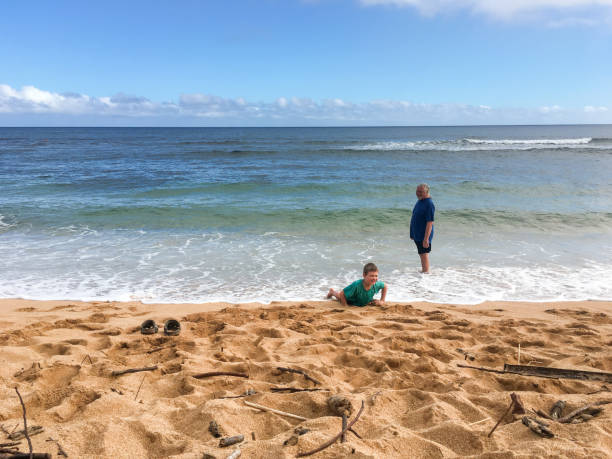 istock Child playing in ocean with Grandfather watching 693070974