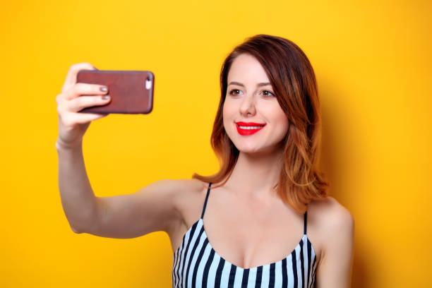 istock Woman making selfie on yellow background 693071690