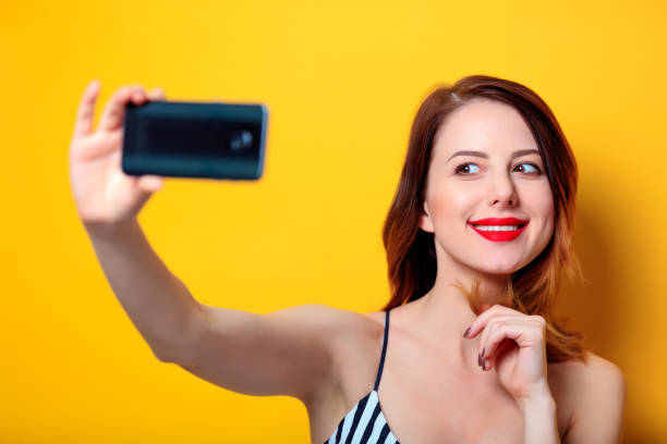 istock Woman making selfie on yellow background 693071692