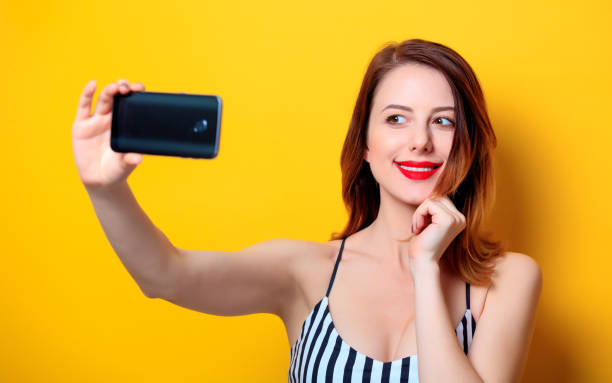 istock Woman making selfie on yellow background 693071696