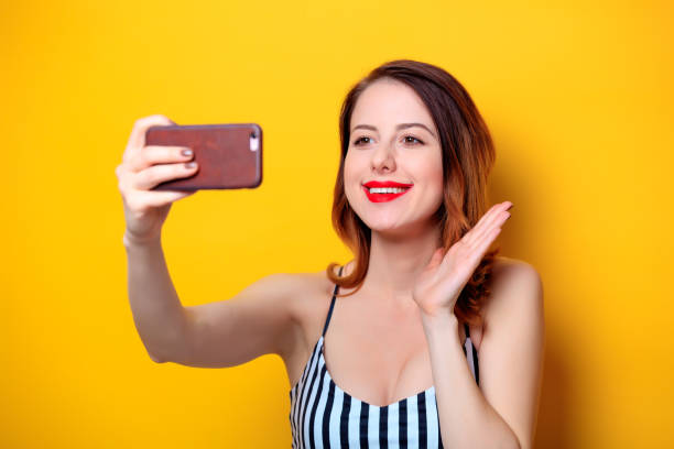 istock Woman making selfie on yellow background 693071700