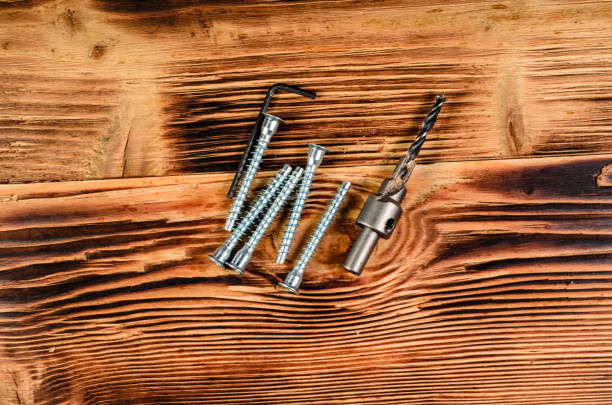 Drill bit and confirmats on wooden table. Top view Drill bit and confirmats on rustic wooden table. Top view boreray and stac lee stock pictures, royalty-free photos & images