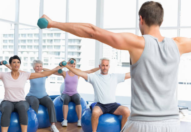 istock Fitness class with dumbbells sitting on exercise balls 693088194