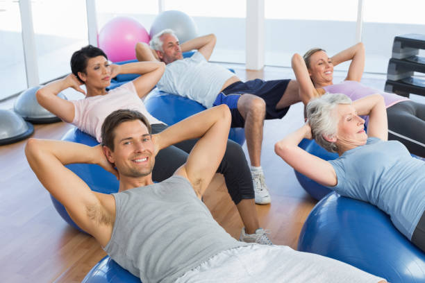 istock Smiling people stretching on exercise balls in gym 693088260