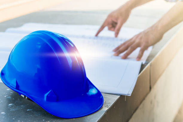 istock The blue safety helmet with the man verify blueprint for his project 693100306