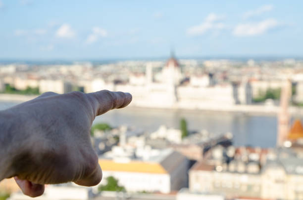 istock Hand with finger pointing at Danude River and Budapest Parliament. 693100460