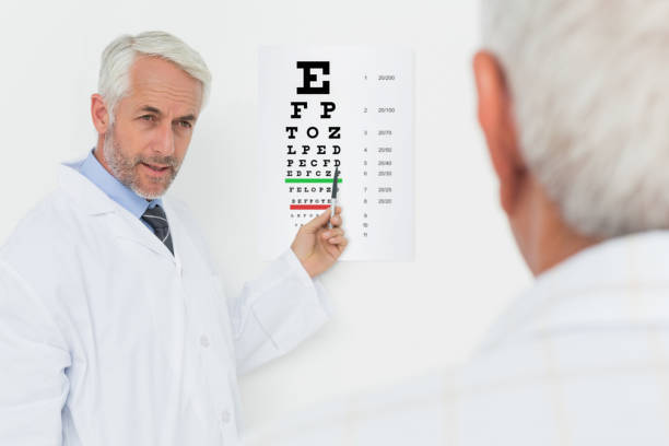 istock Pediatrician ophthalmologist with senior patient pointing at eye chart 693106300